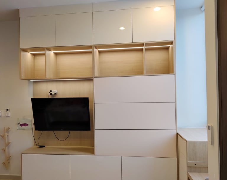 Modern white and wood wall-mounted entertainment center with flat-screen TV, open shelving, and closed storage cabinets in a contemporary bedroom