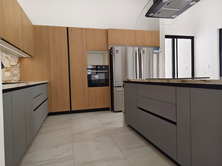 Modern kitchen with wood and gray cabinetry, stainless steel refrigerator, and tiled flooring